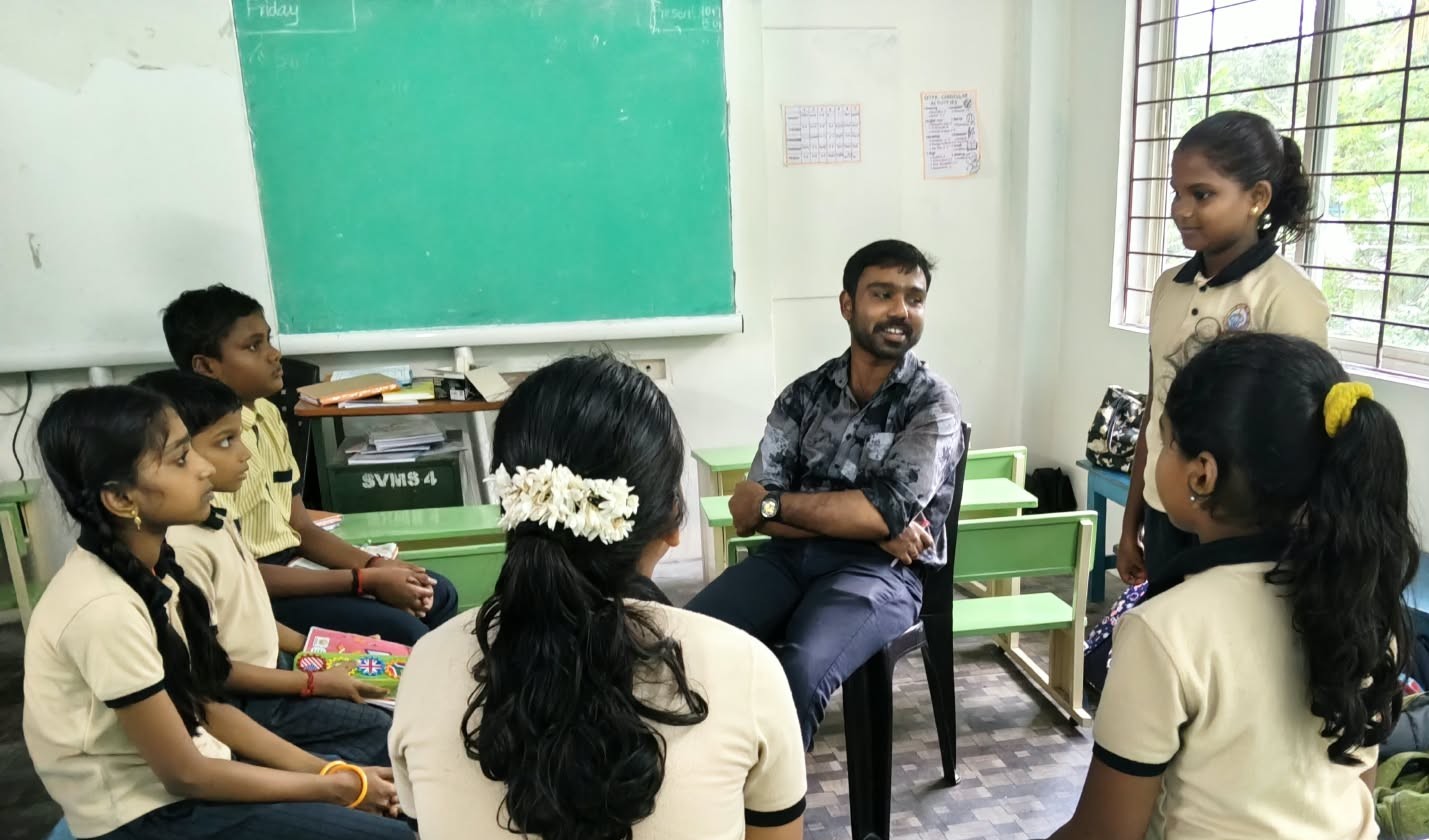 Student speaking with a teacher and classmates